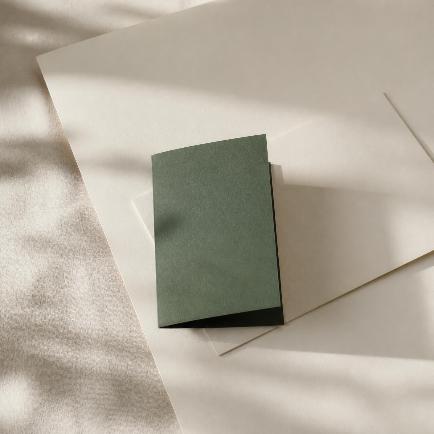 Layered paper and a folded card in soft raking light